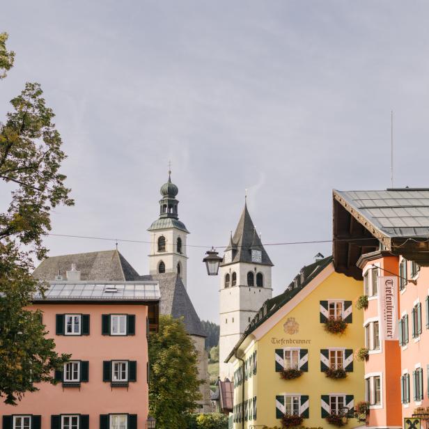 Blick auf Kitzbühel mit bunten Häusern und Kirchtürmen.