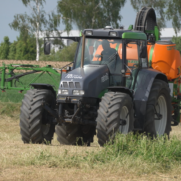 Ein Traktor mit Sprühgerät behandelt ein Feld mit Pflanzenschutzmitteln.