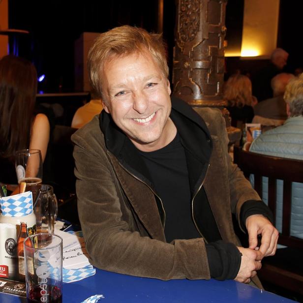 Max Müller sitzt an einem Tisch in einem Restaurant.