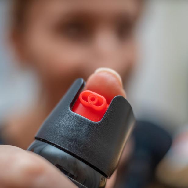 Close up of pepper spray in the girl's hand in the room