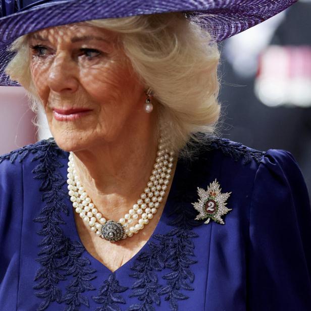 Königin Camilla trägt einen Hut und eine Perlenkette.