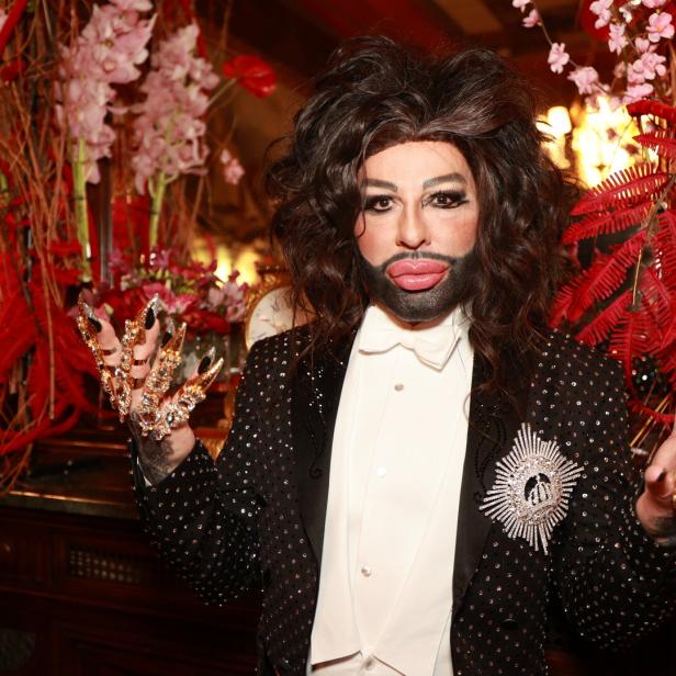 Harald Glööckler posiert in einem mit Pailletten besetzten Smoking und auffälligem Schmuck.