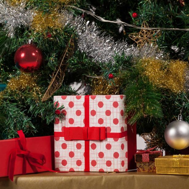 Geschmückter Christbaum mit eingepackten und schön dekorierten Geschenken.