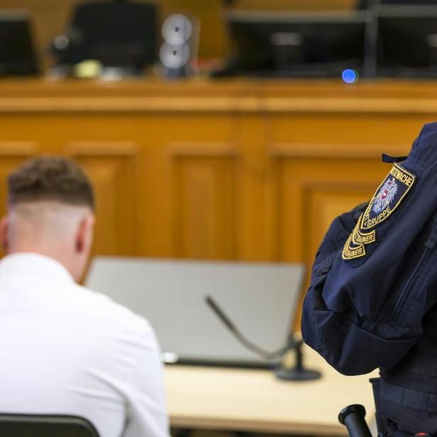 Justizwachebeamter und Angeklagter in Gerichtssaal.