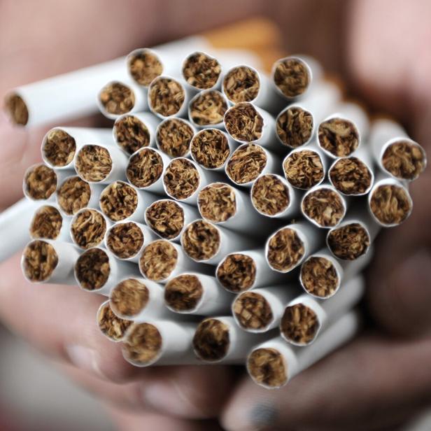 Eine Hand hält ein Bündel Zigaretten.