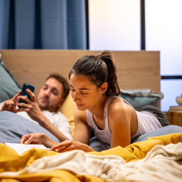 Ein Paar liegt in einem Bett. 