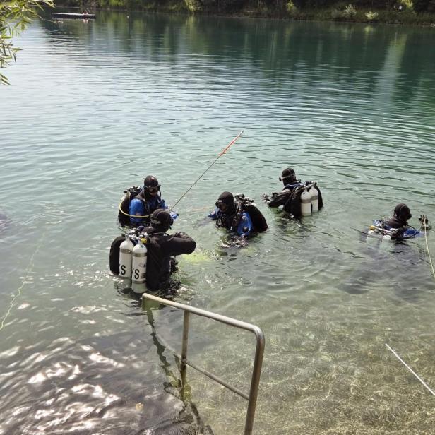 Eine Gruppe von Tauchern bereitet sich im flachen Wasser auf einen Tauchgang vor.