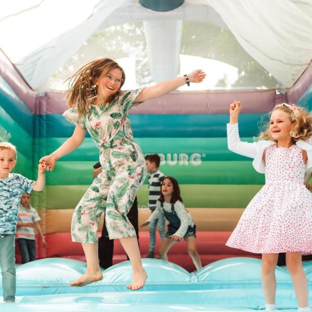 Kinder spielen auf einer Hüpfburg 