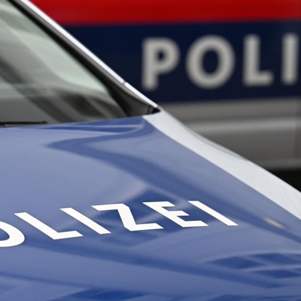 Polizeischriftzug auf zwei vorfahrenden Polizeiautos.