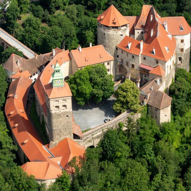 Luftaufnahme der Burg Forchtenstein, umgeben von dichtem Grün.