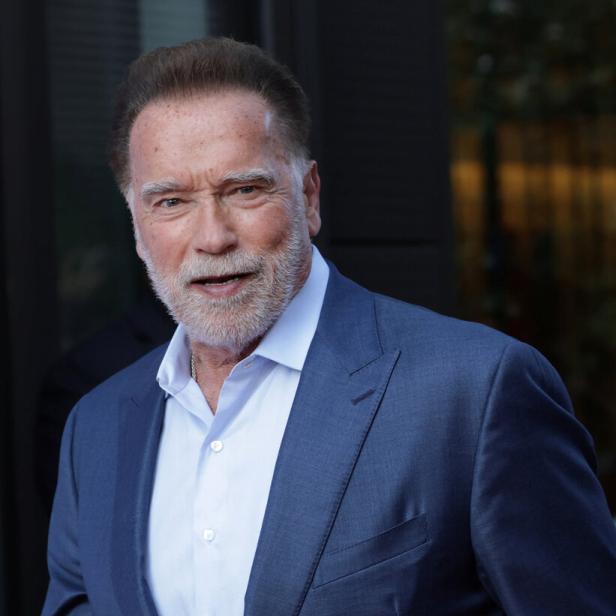 Arnold Schwarzenegger trägt einen blauen Anzug.