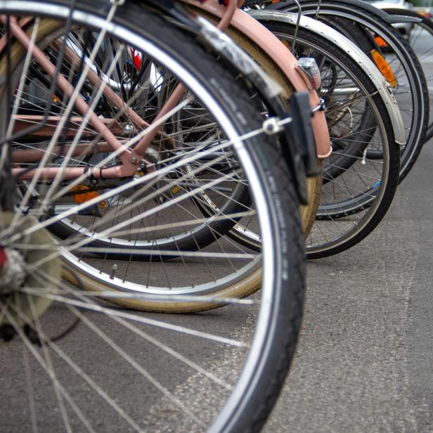 Mehrere Fahrräder stehen nebeneinander auf einem Parkplatz.