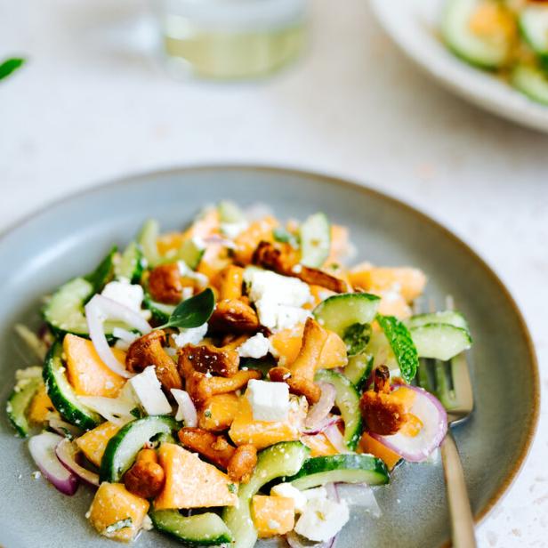 Ein Teller mit Salat aus Pfifferlingen, Gurken, Feta und roten Zwiebeln.