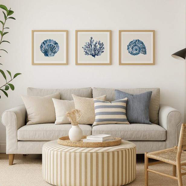 Ein Wohnzimmer mit einem Sofa und drei Bildern mit maritimen Motiven an der Wand.