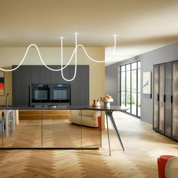 Moderne Küche mit großem Inselbereich und Holzfußboden.