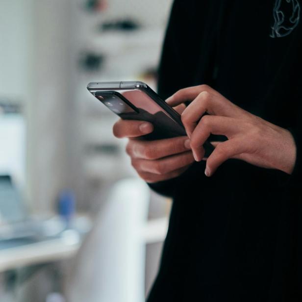 Mann hält Smartphone in Händen