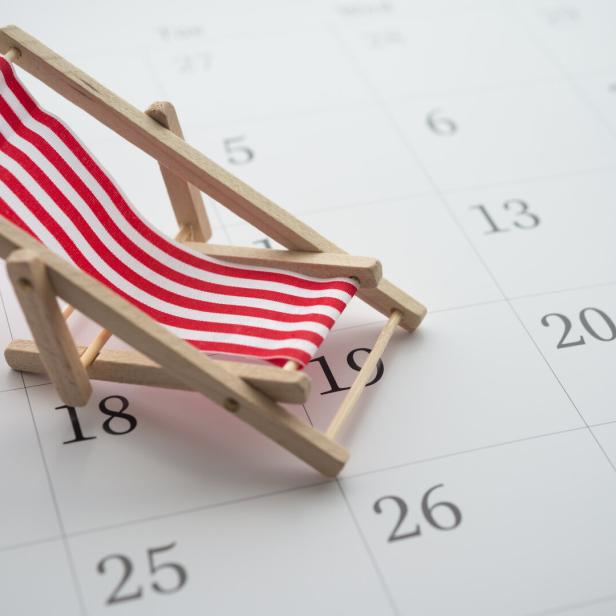 Red beach chair on white blank calendar background copy space.