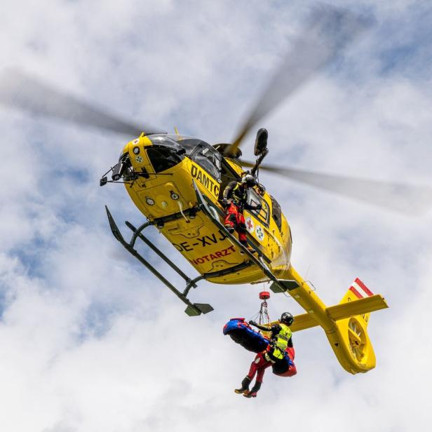 Ein gelber ÖAMTC-Hubschrauber bei einer Rettungsaktion.