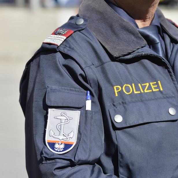 Polizist mit Schriftzug Polizei auf Uniform.