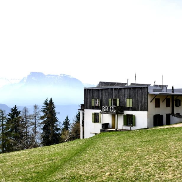 Das Hotel Briol in den Bergen mit Blick auf eine grüne Wiese.