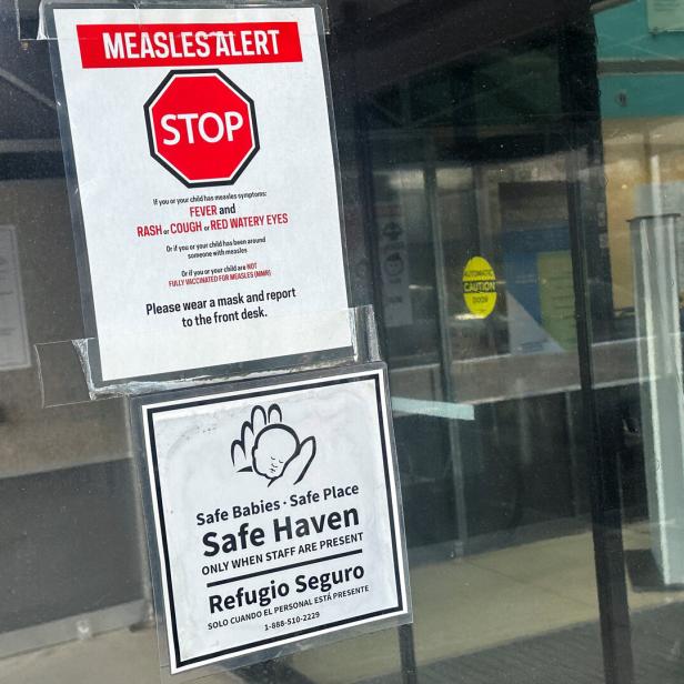 Das Bild zeigt den Eingang zu einem kindermedizinischen Zentrum in New York mit einem Warnschild vor Masernsymptomen