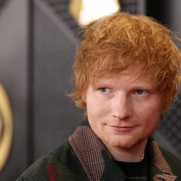 Ed Sheeran mit kariertem Jackett blickt zur Seite.