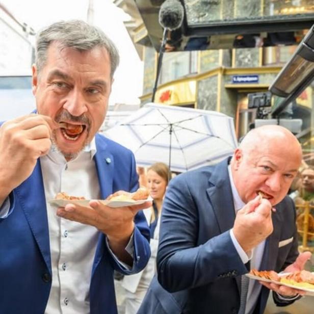 Markus Söder mit Wurst. Im Hintergrund Christian Stocker mit Wurst.