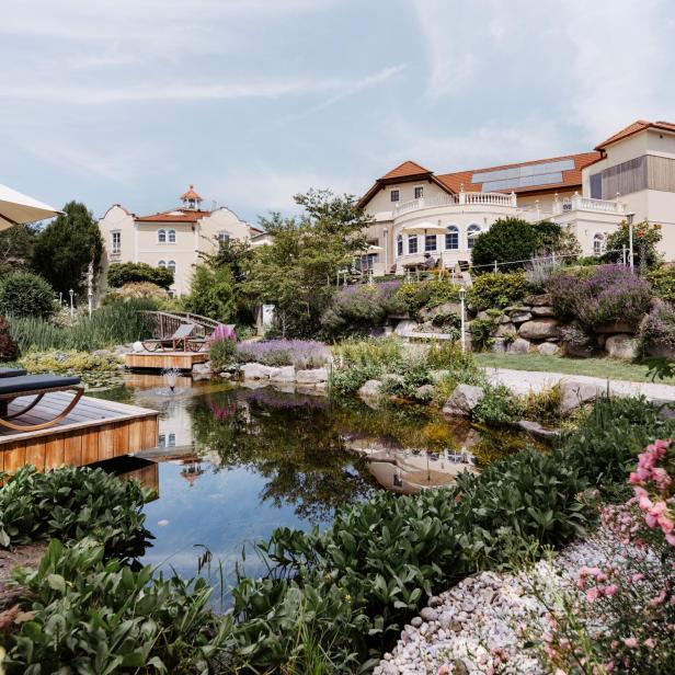 Ein schönes Haus mit großer, begrünter Gartenanlage und einem Teich.