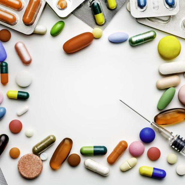 Large group of assorted capsules, pills and blisters making a frame on white background