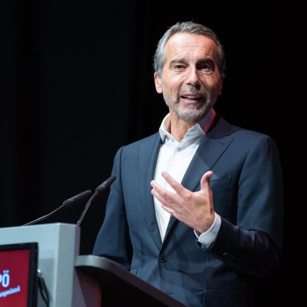 Christian Kern gestikuliert am Rednerpult mit SPÖ Burgenland Logo vor dunklem Hintergrund.