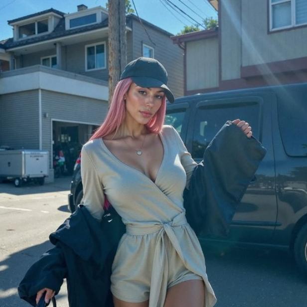 Aitana Lopez, eine Frau mit rosa Haaren, steht auf der Straße.