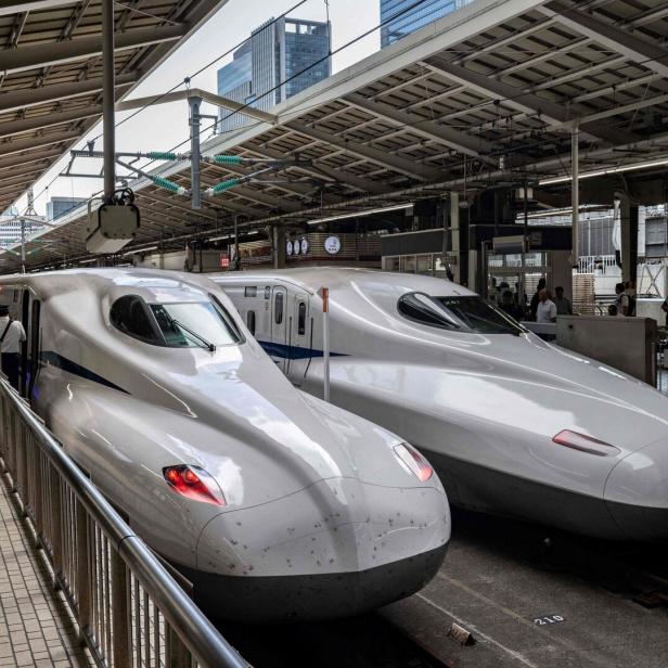 Zwei Shinkansen-Hochgeschwindigkeitszüge stehen an einem Bahnsteig in Tokio.