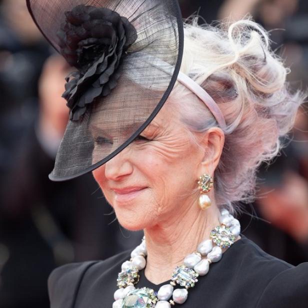 Helen Mirren mit einem eleganten Hut und einer auffälligen Perlenkette.