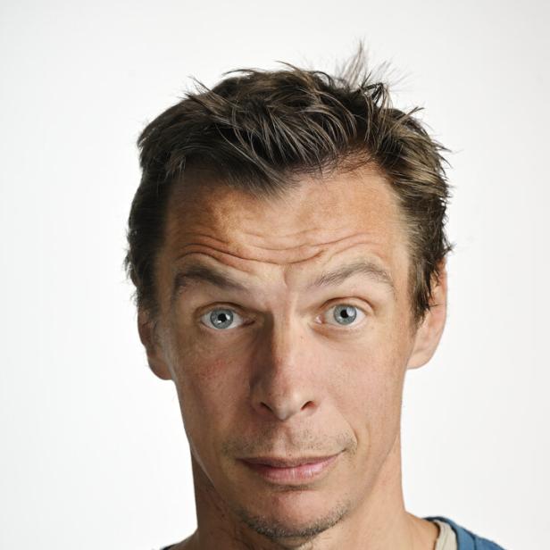 Ein Mann mit blauen Augen und leicht fragendem Gesichtsausdruck blickt in die Kamera.