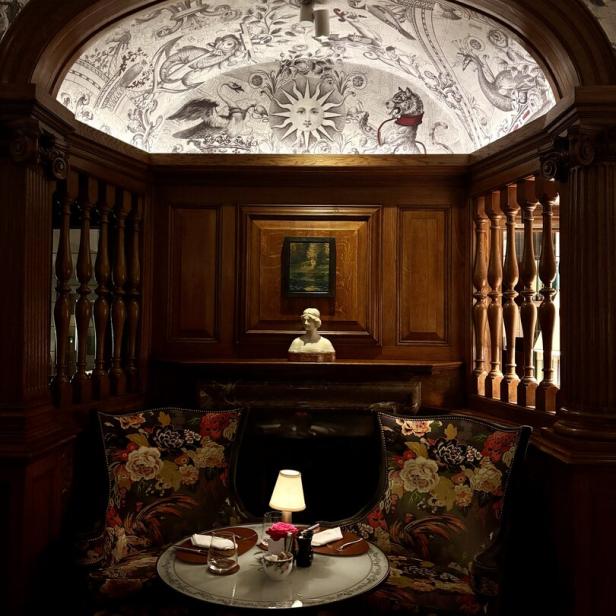 Ein gemütlicher Sitzbereich im Brown Hotel mit floralen Sesseln und einem gedeckten Tisch.