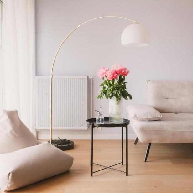 Ein Wohnzimmer mit einem Sofa, einem Tisch und einer Vase mit Blumen.