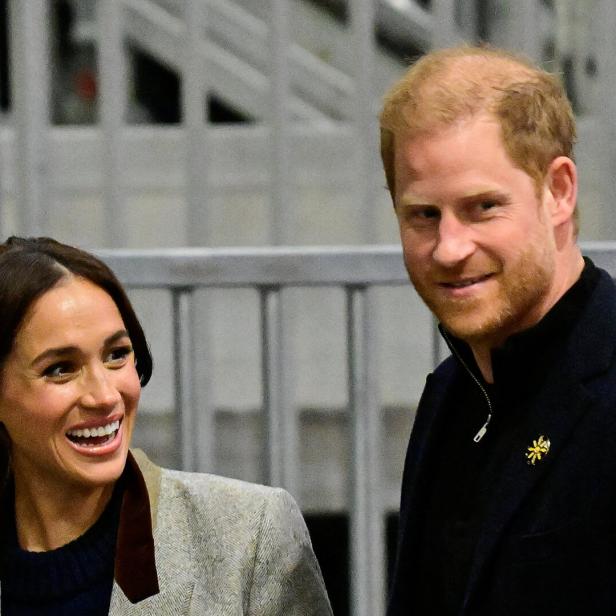 Harry und Meghan lächeln in die Kamera.