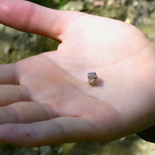 Junge Frau findet Diamanten in der Erde.