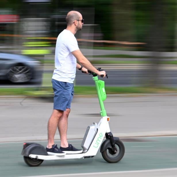 Mann auf E-Scooter ohne Helm