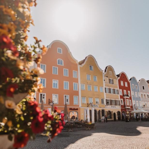 Barock Bürgermhäuser auf einem großen Platz, auf dem Blumenkisten stehen.