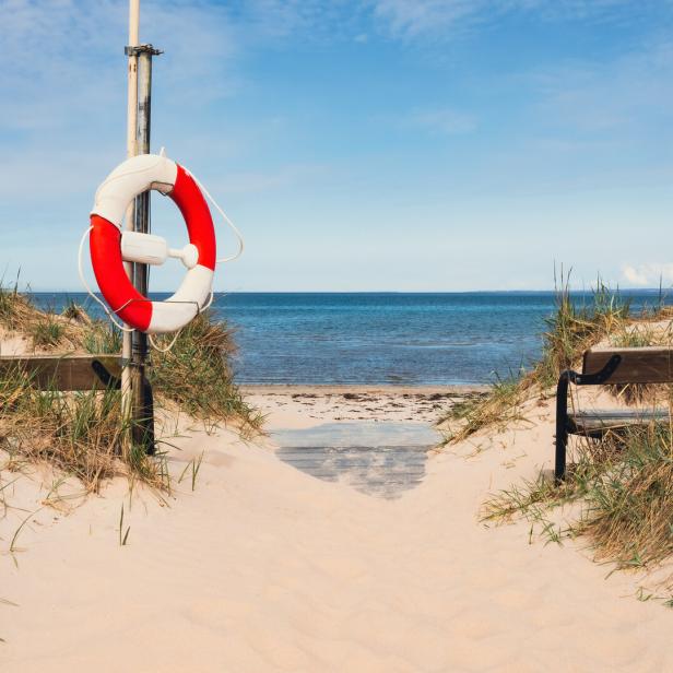 Bänke an einem wunderschönen weißen Sandstrand in Südschweden, einem beliebten Touristenziel.