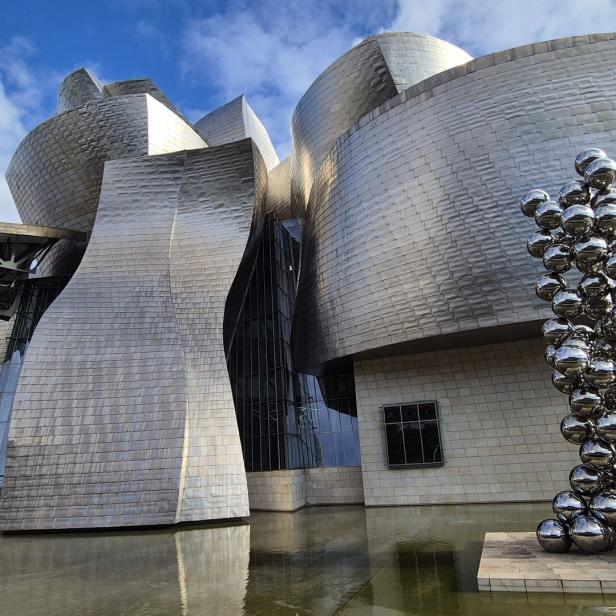 Das Guggenheim-Museum in Bilbao mit einer Skulptur aus glänzenden Kugeln.
