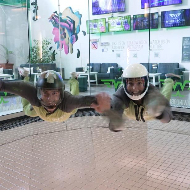 Zwei Männer fliegen in der Luft, in einem Weltraumsimulator. 