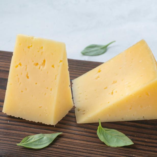 Zwei Stück Käse auf einem Holzbrett