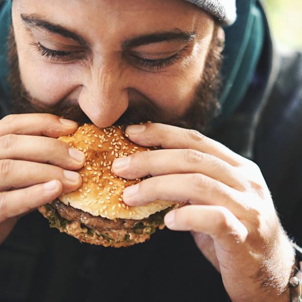 Mann beißt in Buger.