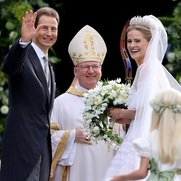 Erbprinz Alois mit seiner Tochter Prinzessin Marie Caroline und Bischof Benno Elbs. Alois winkt, die Braut trägt ein weißes Kleid mit Tiara und langem Schleier.
