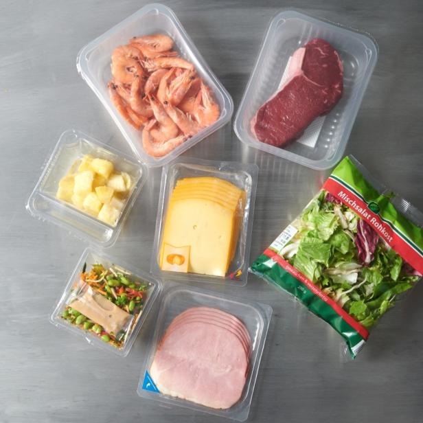 Eine Auswahl an Fleisch, Käse und Gemüse in Plastikbehältern, appetitlich angerichtet.