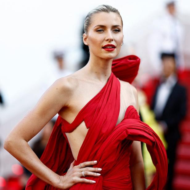 Lena Gercke posiert in einem roten Kleid auf einem roten Teppich.