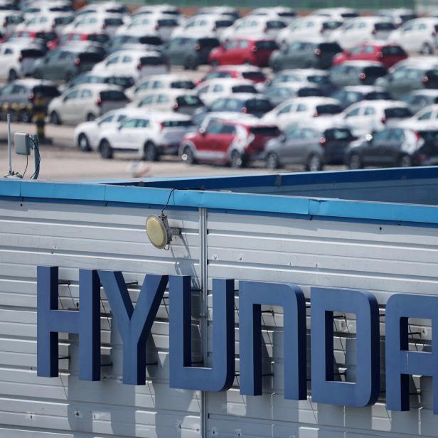 Eine große Anzahl an Autos steht bereit. Davor sieht man ein Hyundai-Logo.