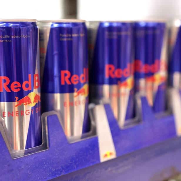 Dosen des Energy-Drinks Red Bull stehen in einem Supermarktregal.